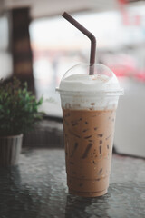 Iced coffee latte with drinking straw on table