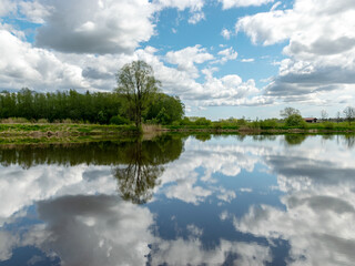 calm scene of beautiful sky with cumulus clouds reflection on the lake