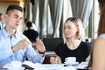 Business meeting in a cafe young businessmen