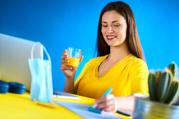 woman drinks juice and works during quarantine