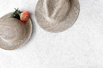 Straw hats for woman and man on concrete background.