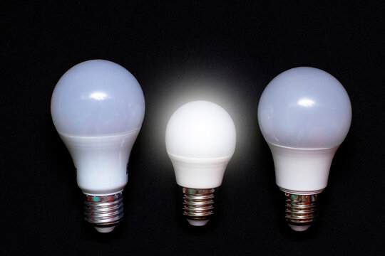 Three LED lamps in different sizes. The small lamp is lit. Electricity Saving Concept. The photo