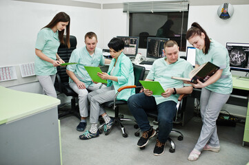 Fototapeta premium Medical theme.Observation room with a computer tomograph. The group of doctors meeting in the mri office at diagnostic center in hospital.