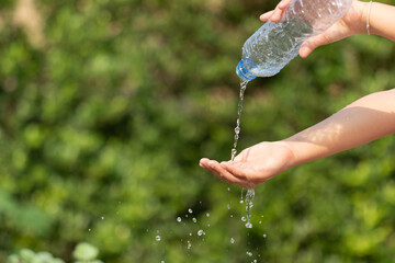 Water from tab pouring in hand on nature background, Concept for save water,conservative environment