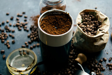 Coffee beans in an old vintage coffee grinder on a dark background. Freshly ground coffee and beans before preparing a drink