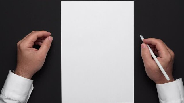 top view of a blank sheet of paper and a businessman's hands on a black table, white shirt and wrist watch