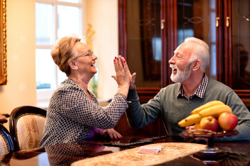 Senior couple having fun while playing dominos