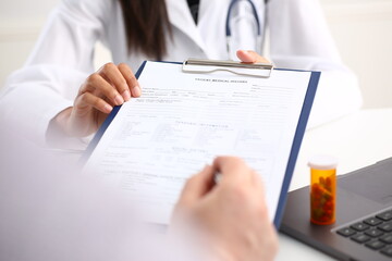 Female doctor hand hold silver pen and showing pad. Physical agreement form signature disease prevention ward round reception consent contract sign prescribe remedy healthy lifestyle concept