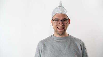 Portrait of joyfully smiles attractive man in foil hat and glasses. Emotional handsome guy with a...