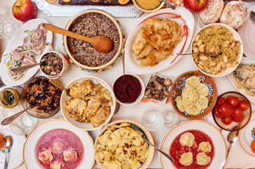 Traditional Ukrainian food. Kutya, borsch, dumplings, cabbage rolls on festive table.