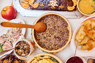 Traditional Ukrainian food. Kutya, borsch, dumplings, cabbage rolls on festive table.
