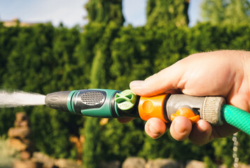 Gartenbewässerung mit einem Gartenschlauch in der Hand