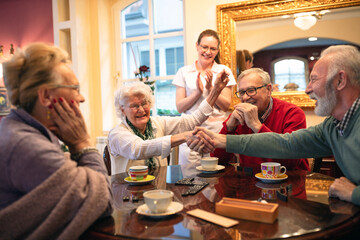 Senior woman celebrates a board game win