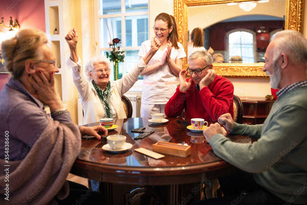 Wall mural older woman wins in a domino game and celebrates it