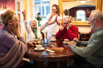 Older woman wins in a domino game and celebrates it