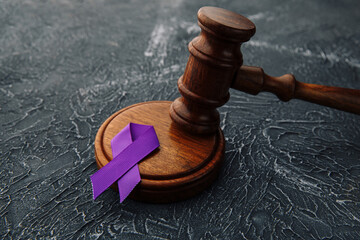 Violet ribbon and gavel on grey background - Concept of Domestic Violence law