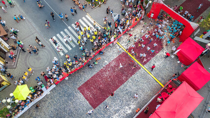 Marathon running race, aerial view of start and finish line with many runners from above, road...