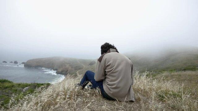 Person sits above windy cove