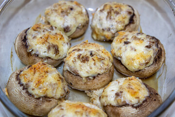 Stuffed mushrooms stuffed with cheese, mushroom stalks and onions. In a baking dish.