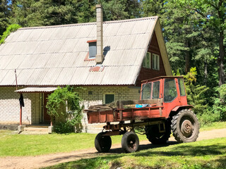 Fototapeta na wymiar old farm tractor, old farm tractor near the old house