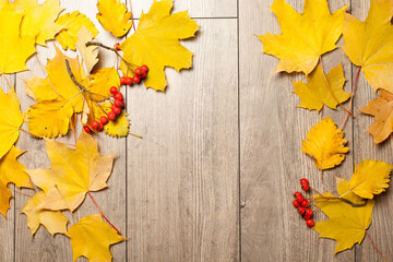 Naklejka na ściany i meble Colorful autumn leaves over wood background with copy space