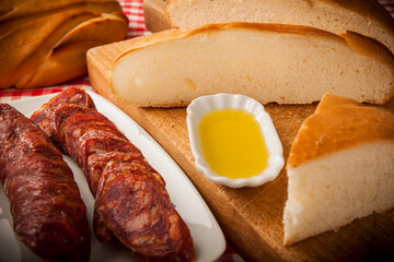 rebanadas Hogaza de pan de pueblo artesano con decoración chorizo aceite sobre tabla de madera