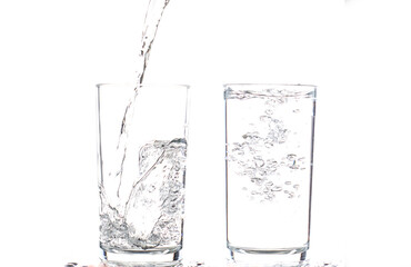 pouring water in to glass isolated on white background