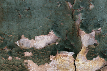 Naklejka premium Cracked paint. Wall with the remains of old green paint.