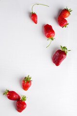 Vertical image.Topv iew of set of fresh delicious strawberries on the white surface.Empty space, board
