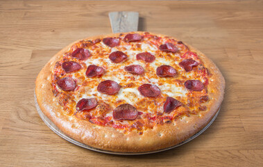 Pepperoni Italian pizza on wooden background