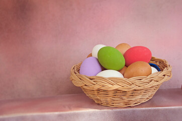 Still life image of woven rattan basket of colored eggs