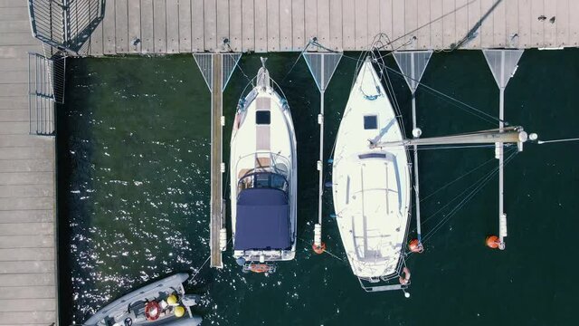 top down yachts moored in the marina at the pier,  boats swaying on the water, close-up on the sail