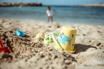 Family beach vacation concept, sand castle and family at sea
