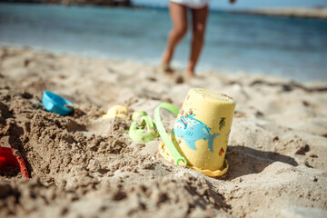 Family beach vacation concept, sand castle and family at sea