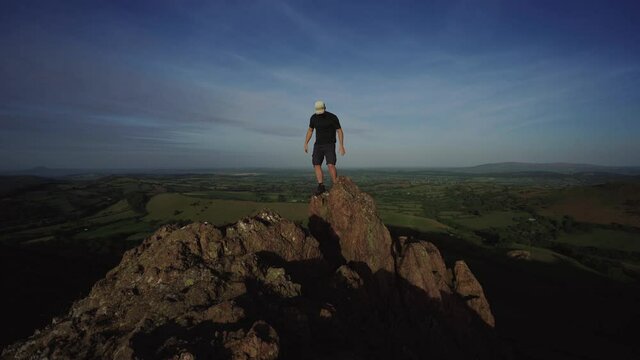 A man climbing a rock in the Shropshire Hills UK
