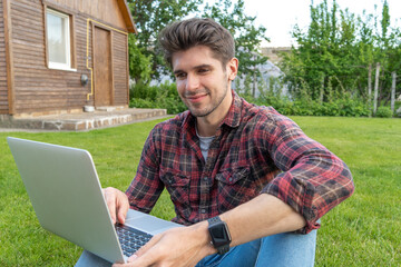 Beautiful  latin young freelancer with a laptop working outside on the grass 
