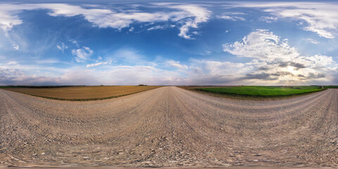 full seamless spherical hdri panorama 360 degrees angle view on no traffic gravel road among fields in evening with cloudy sky in equirectangular projection, ready for VR AR virtual reality content