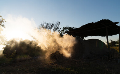 Smoke from antique charcoal kiln made from clay, used for burning charcoal from wood,air pollution...