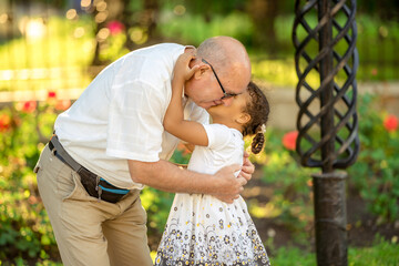 Little granddaughter hugging her grandfather