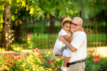 Obraz premium Little granddaughter hugging her grandfather
