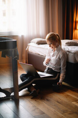  Young businesswoman working on lap top. Beautiful woman working in hotel room.