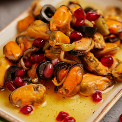 mussel meat in oil with pomegranate seeds