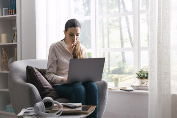 Woman connecting with her laptop at home