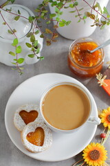 Sweet homemade love sandwich cookies with orange jam and coffee latte