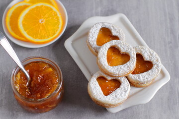 Sweet homemade love sandwich cookies with orange jam and coffee latte