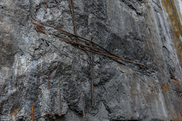 Old damaged concrete wall with rusty armature