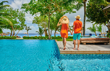 Young couple by poolside. Resort swimming pool at Seychelles.