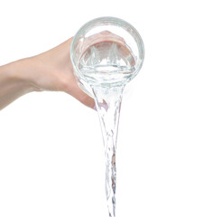 Water is pouring from a glass in hand on white background isolation