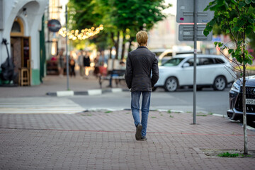Urban landscape design. A Man walking down the street behind the lights of the cafe.