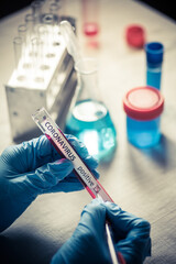 Fototapeta premium Doctor hands holding a coronavirus COVID-19 positive test tube